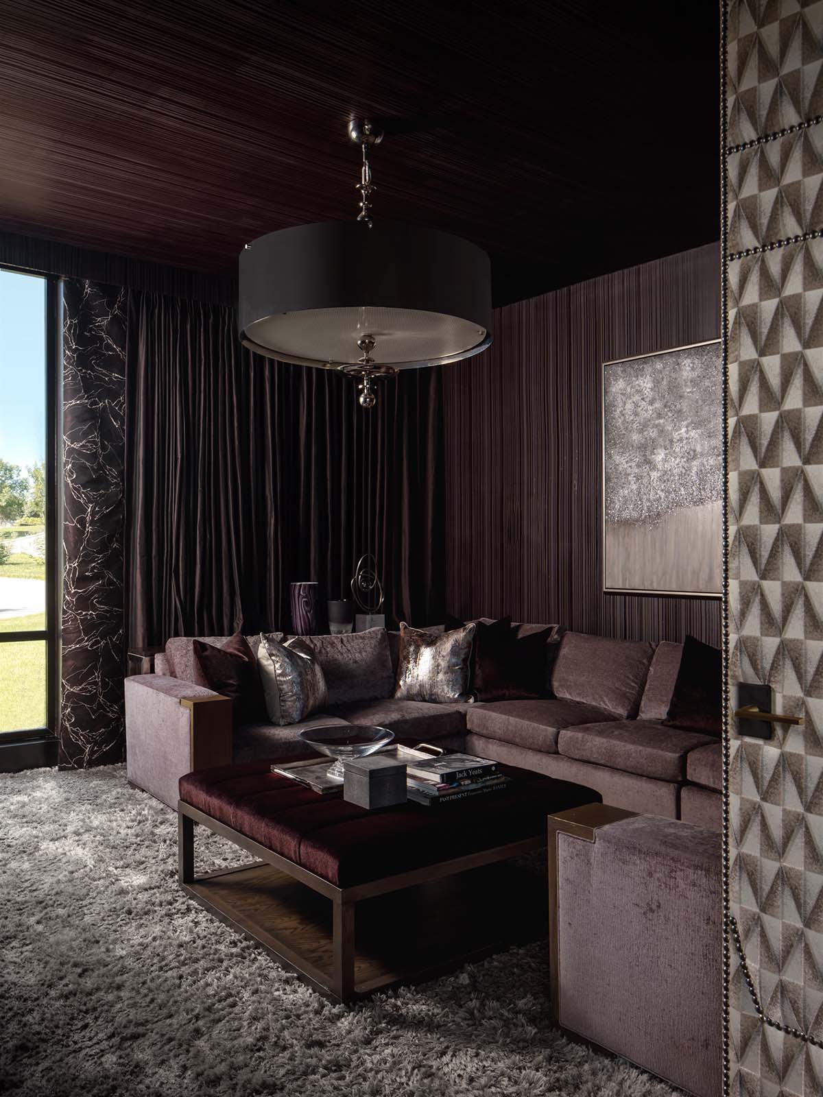Dark moody media room with velvet sectional and shagreen wall panels