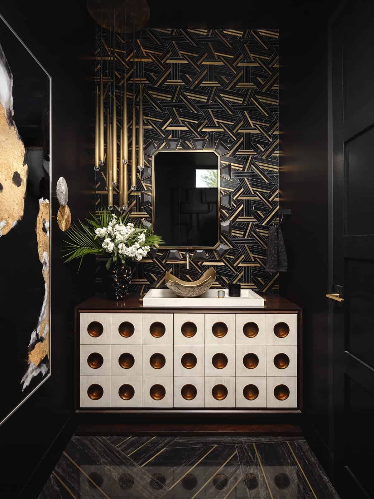 Black powder room vanity with brass circular pulls and geometric mirror