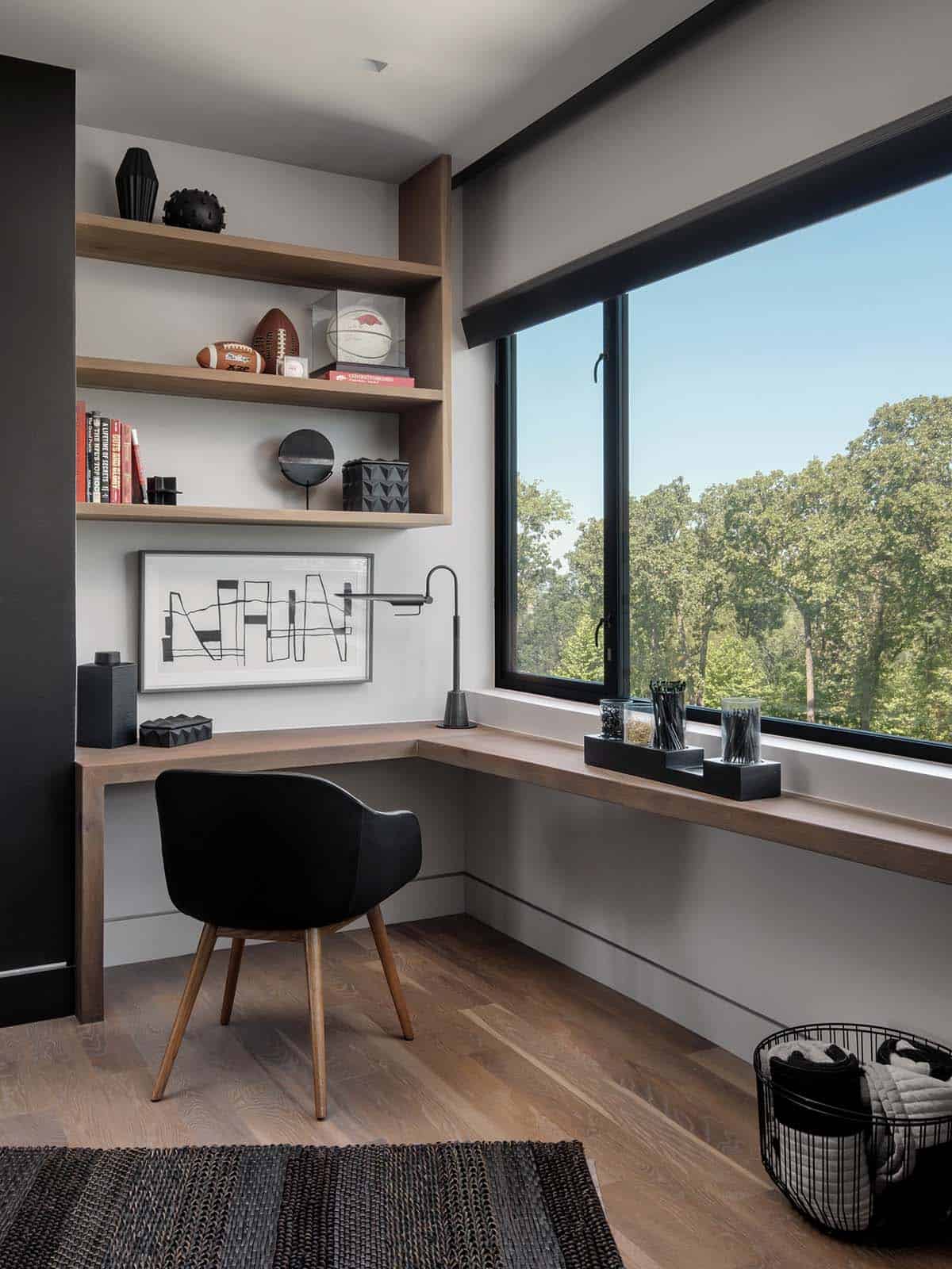 Home office nook with built-in shelving and floor-to-ceiling forest views