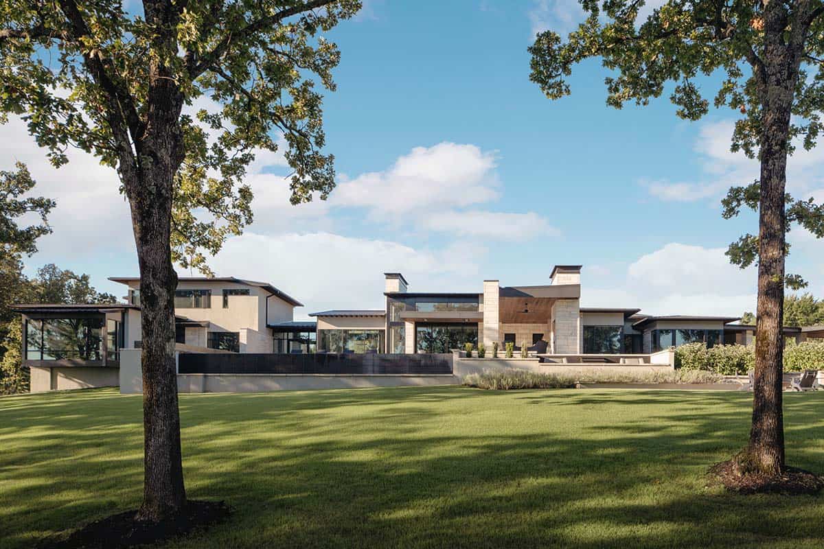 Rear exterior view of the stone home framed by mature oak trees