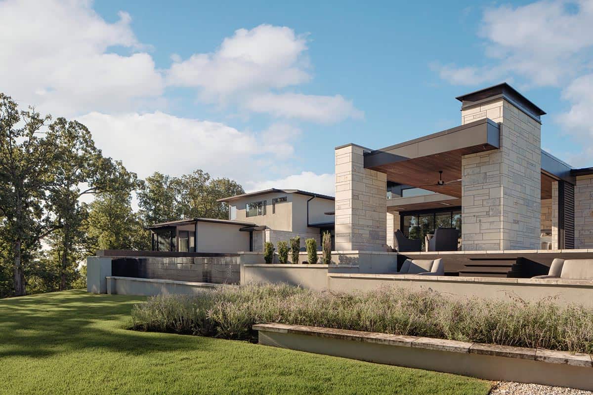 Rear exterior with covered lounge, fireplace wall and infinity pool edge