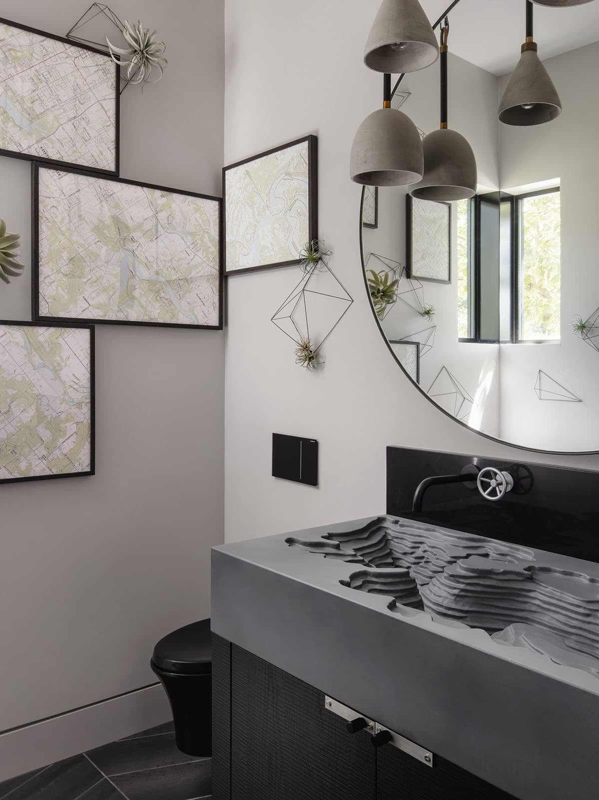 Powder room with sculptural topographic sink and gallery of map art