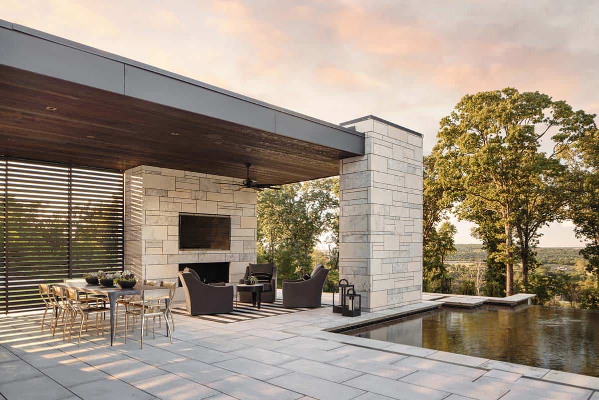 Outdoor living pavilion with stone fireplace and wood-clad ceiling
