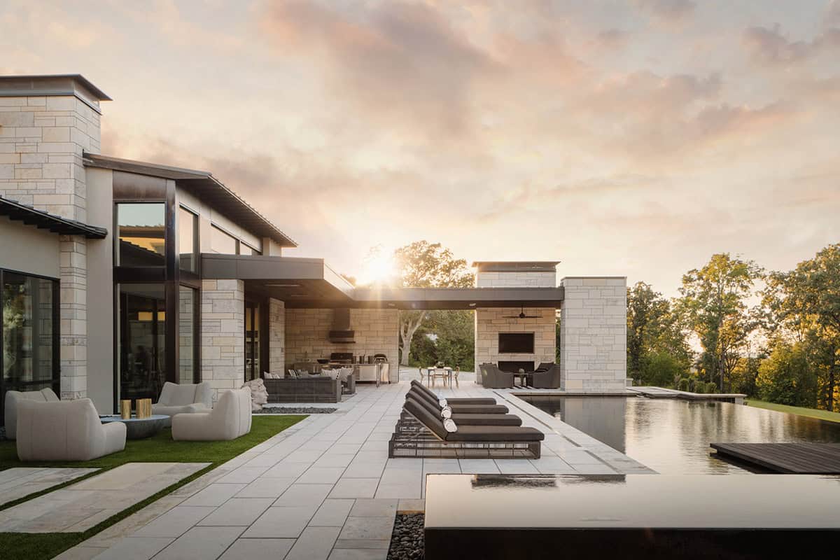 Sunset exterior view of stone terrace, pool and outdoor kitchen