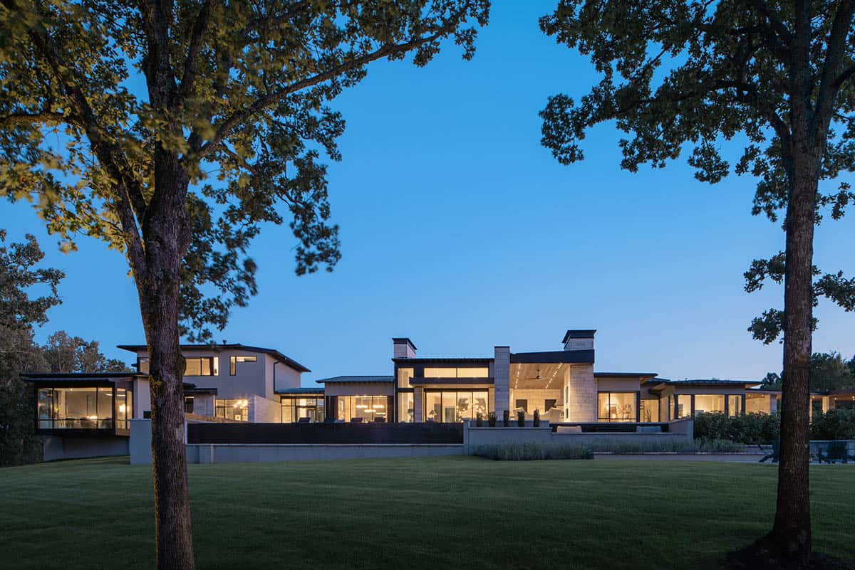 Rear exterior with glowing windows across the stone facade at dusk