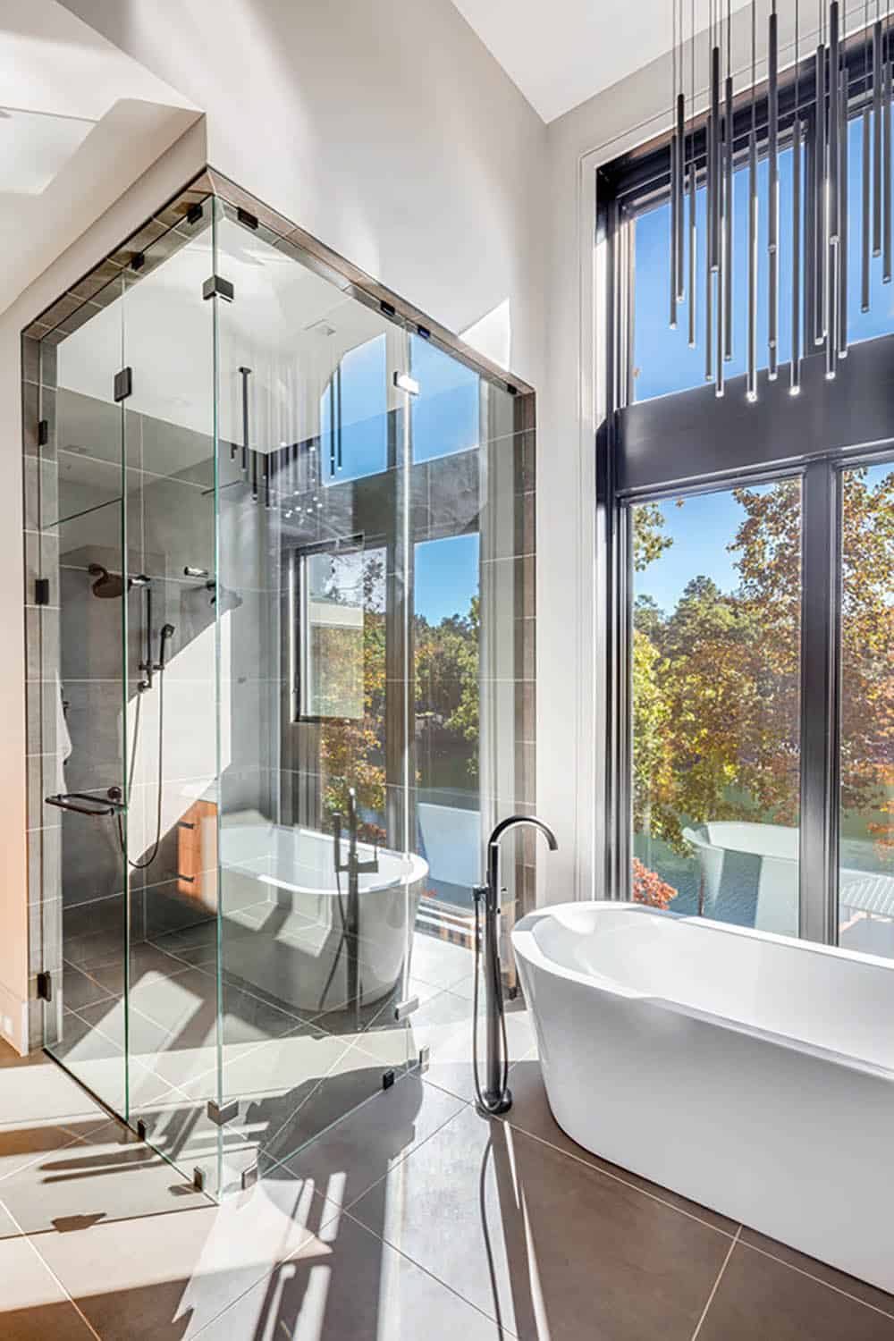 Glass-enclosed shower and soaking tub in a spa-style bathroom with lake views