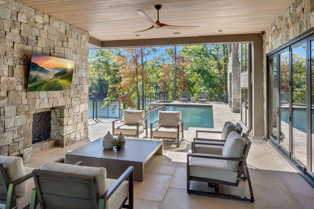 Covered patio lounge area overlooking the infinity pool and lake