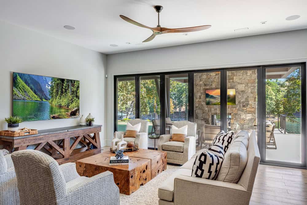 Living room with sectional seating, wood coffee table, and folding glass doors to patio