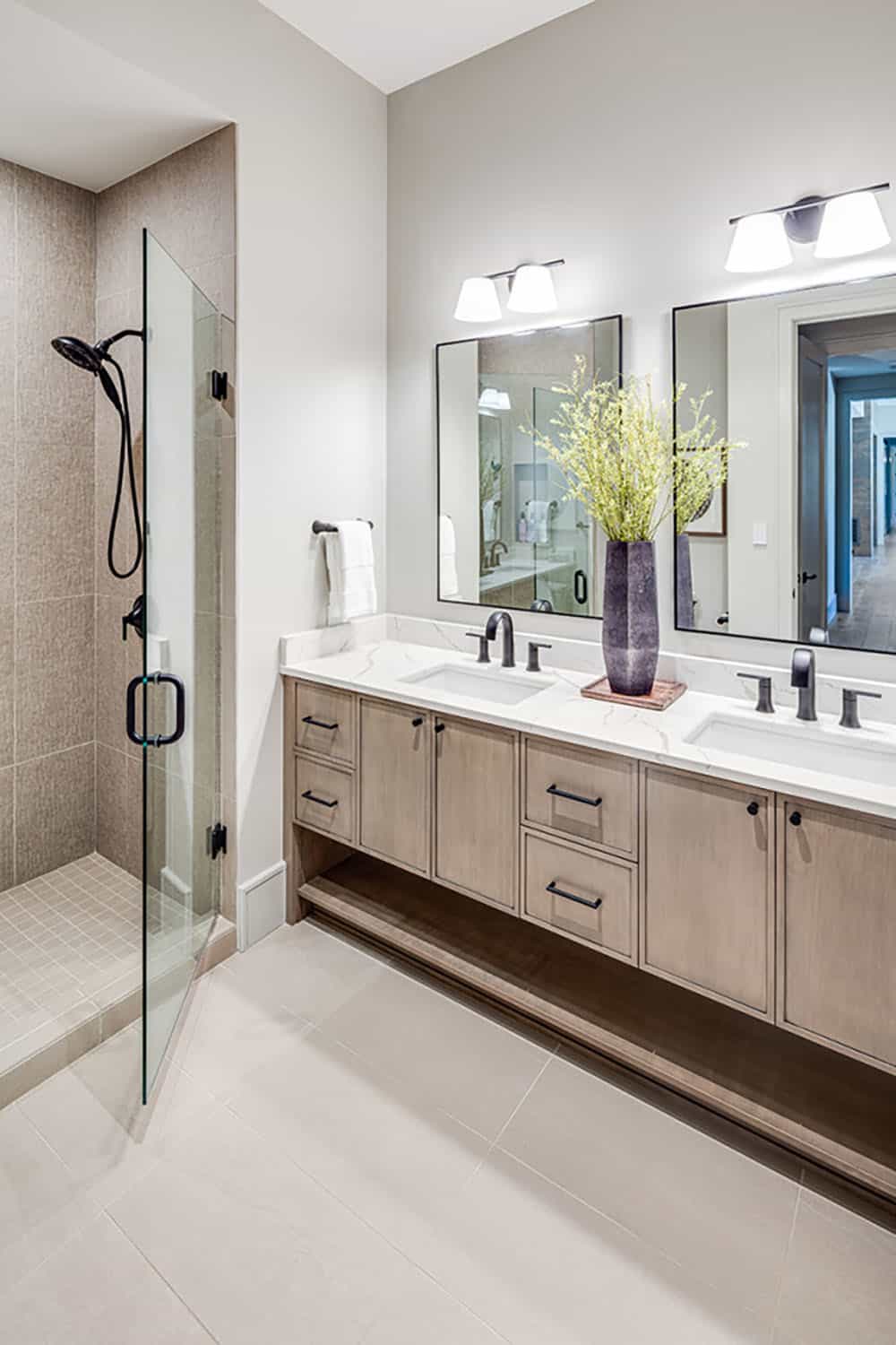 Bathroom with walk-in glass shower and double-sink wood vanity
