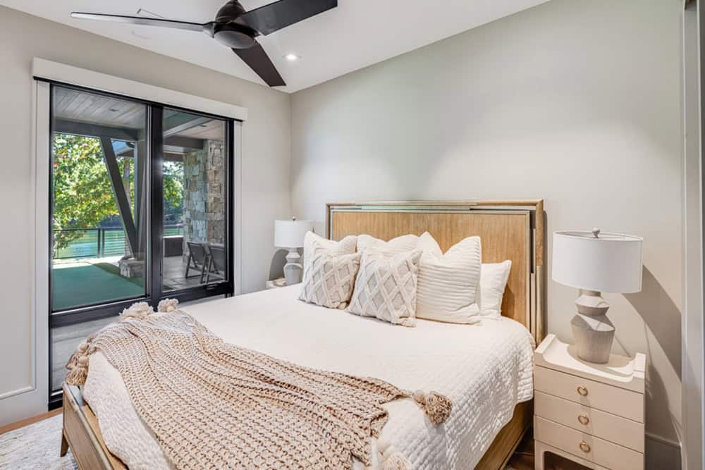 Guest bedroom with wood headboard, knit throw, and sliding doors to patio