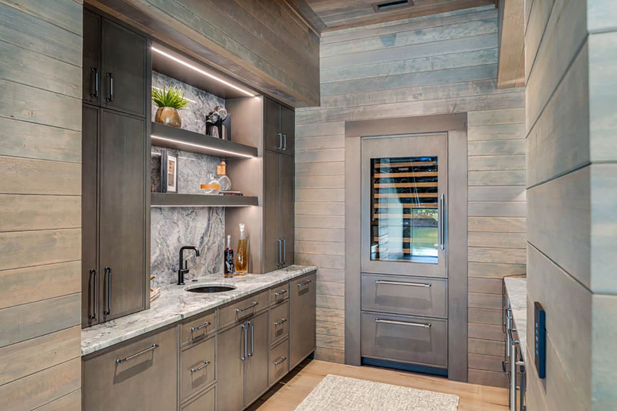 Wet bar with stone backsplash, wood cabinetry, and built-in wine fridge