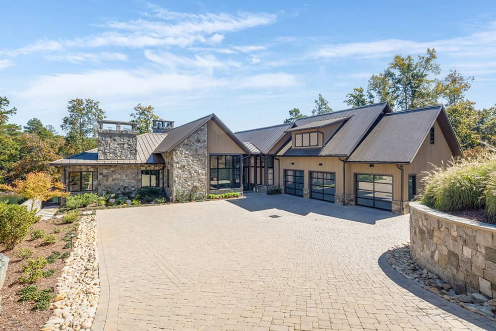 Wide front exterior view of the home with circular stone-walled driveway