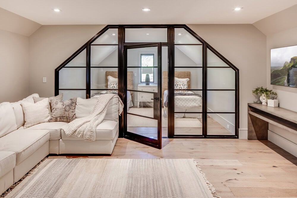 Lounge area with sectional sofa facing a glass-paneled bunk room