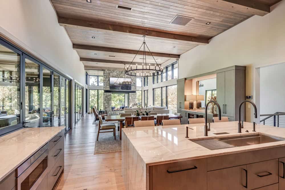 Open-concept kitchen and dining area with wood-beamed ceiling and lake views
