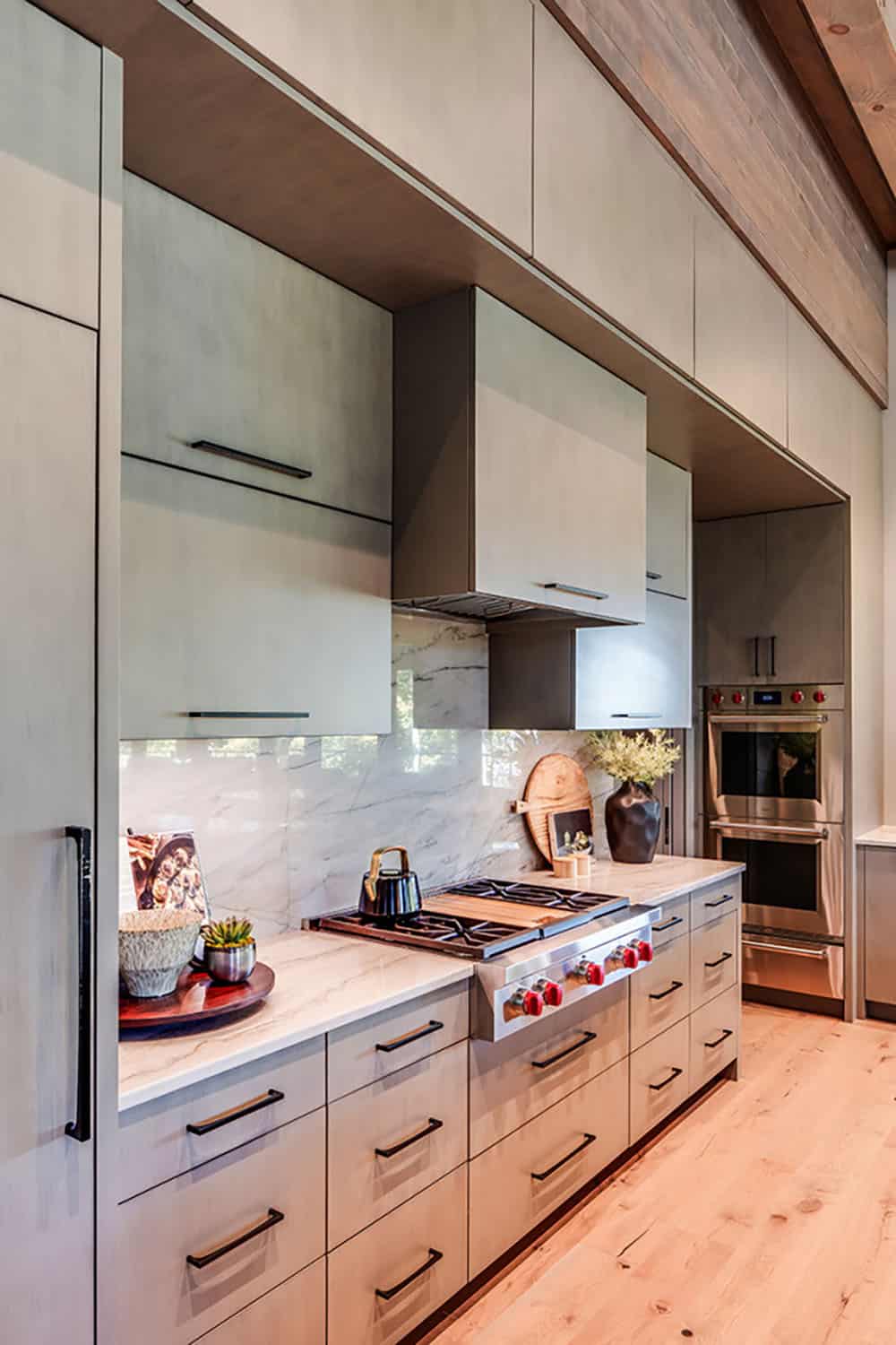 Kitchen cooktop with marble backsplash and built-in double ovens