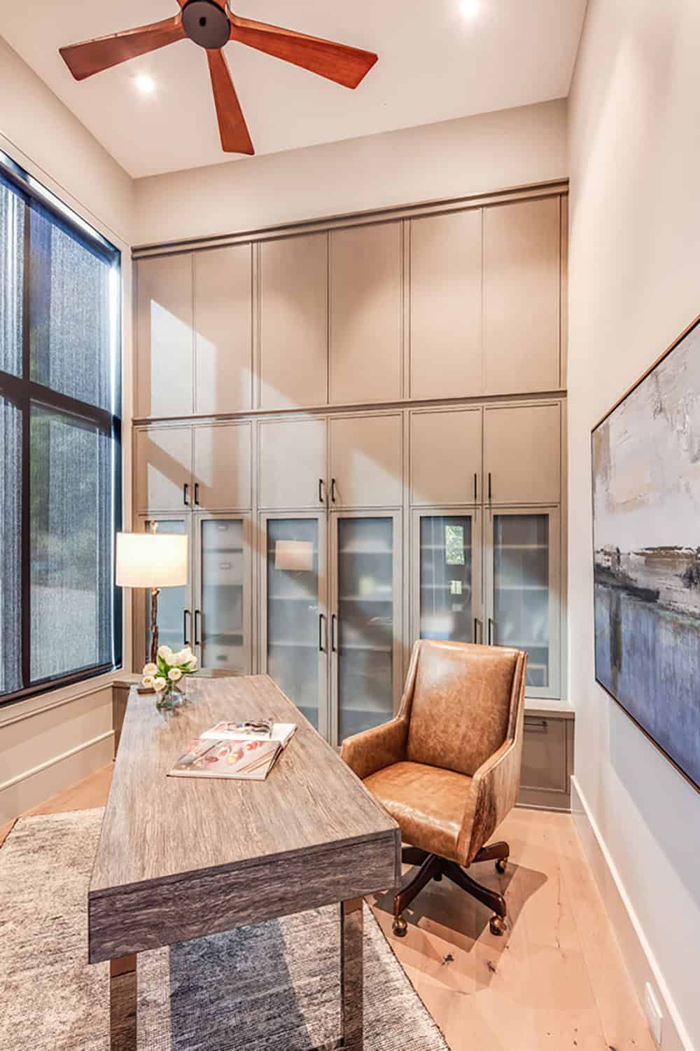 Home office with built-in cabinetry, wood desk, and leather chair