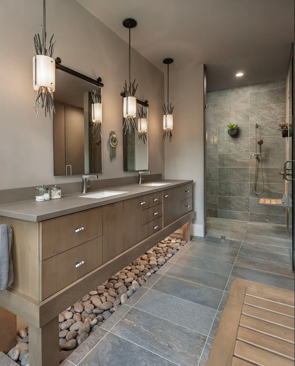 Bathroom vanity and walk-in tile shower with pendant lighting