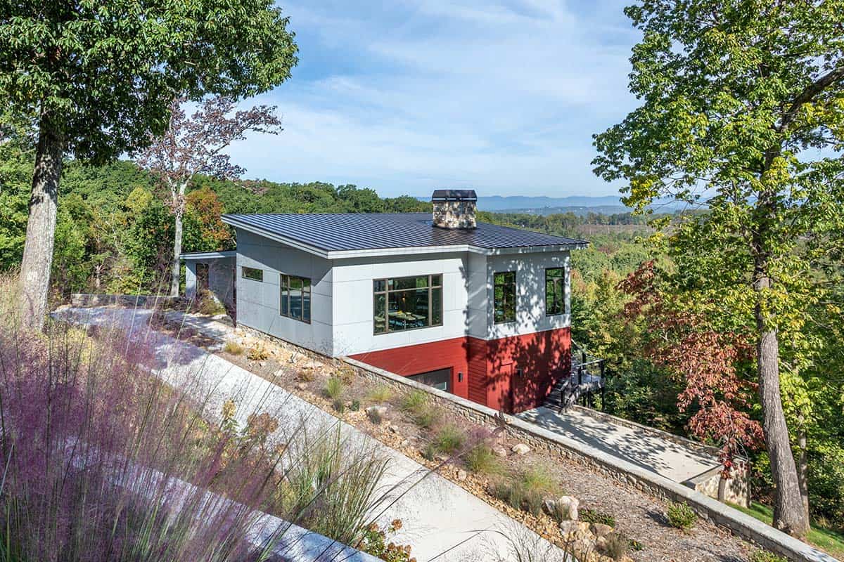 Side exterior view of home with metal roof and stone chimney