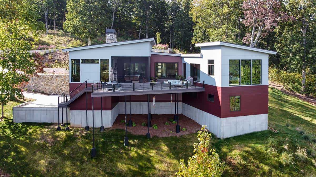 Rear exterior of elevated home with deck and green roof section