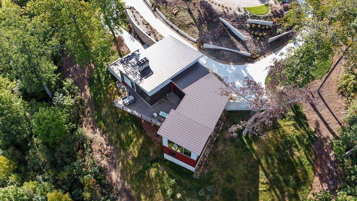 Aerial view of angled rooflines and deck surrounded by trees