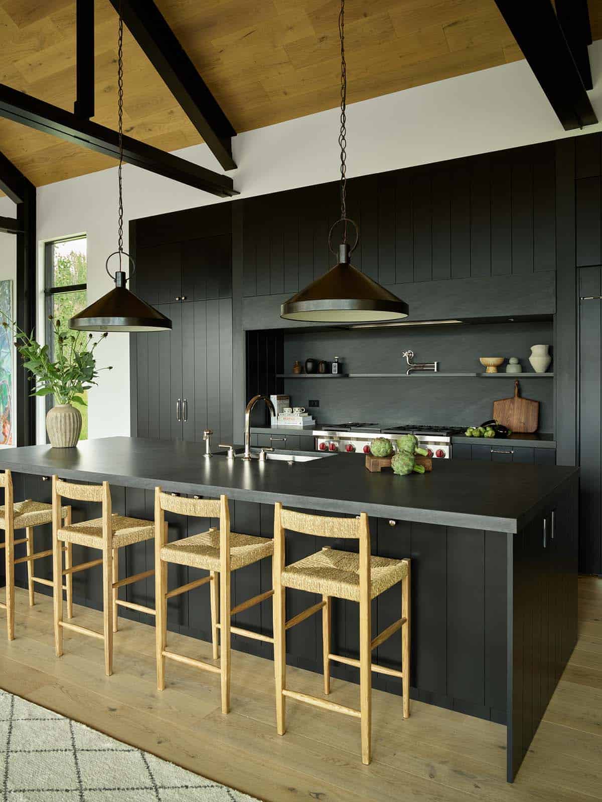 Black kitchen cabinetry with open shelving and dual pendant lights