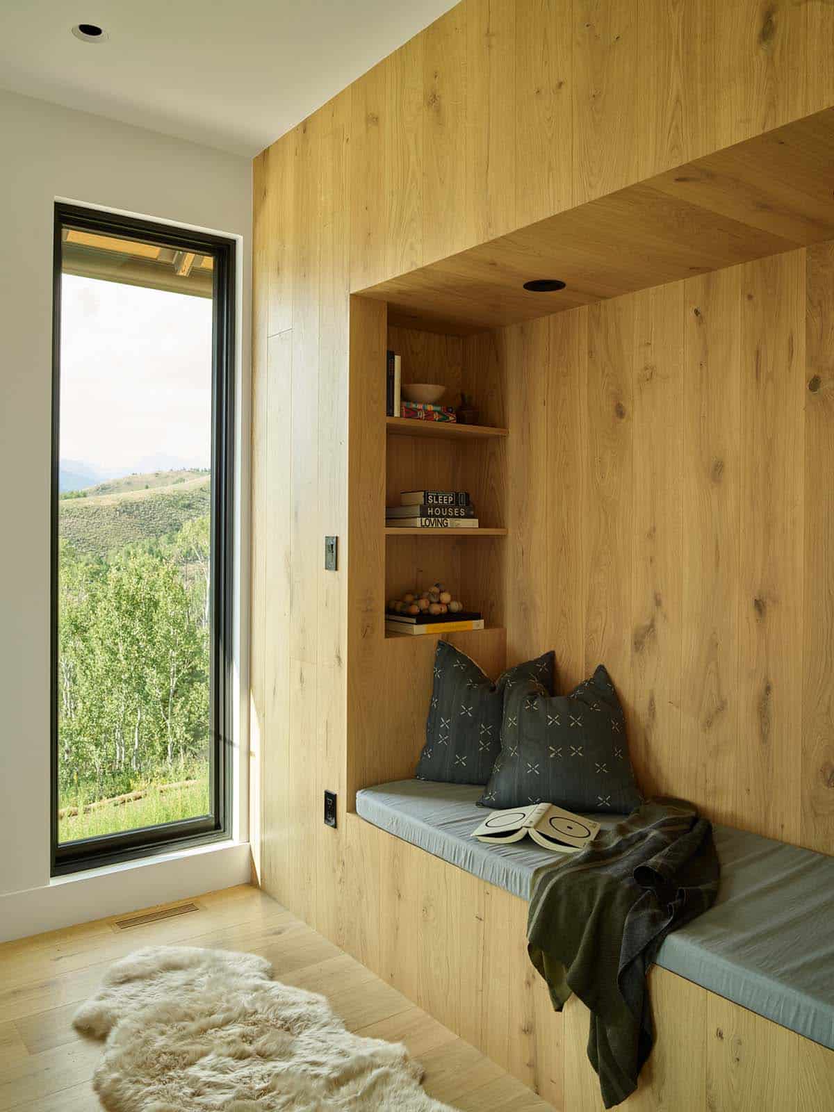 Built-in wood reading nook with bench seating and mountain view window