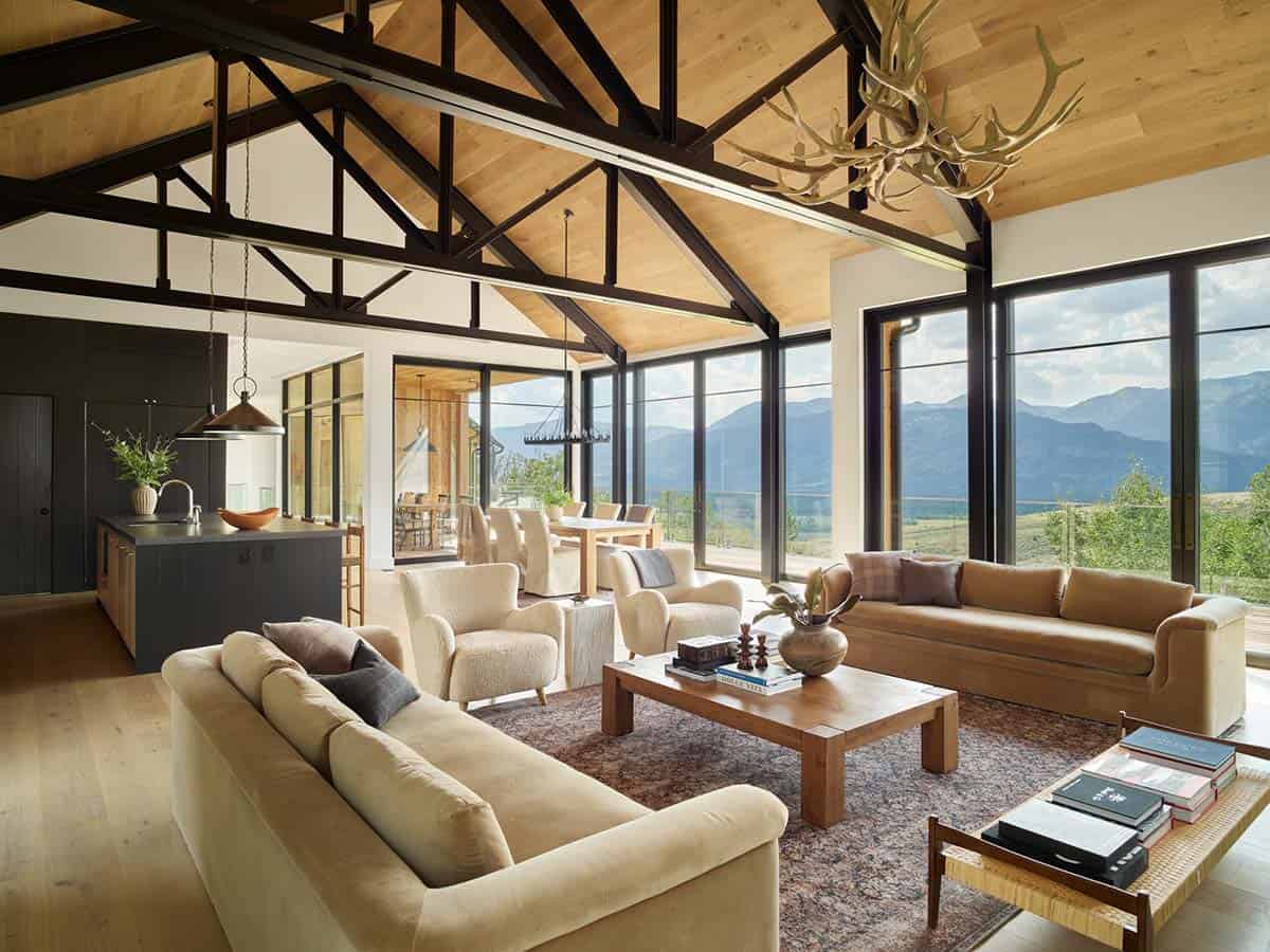 Open living and dining area with vaulted wood ceiling and floor-to-ceiling windows