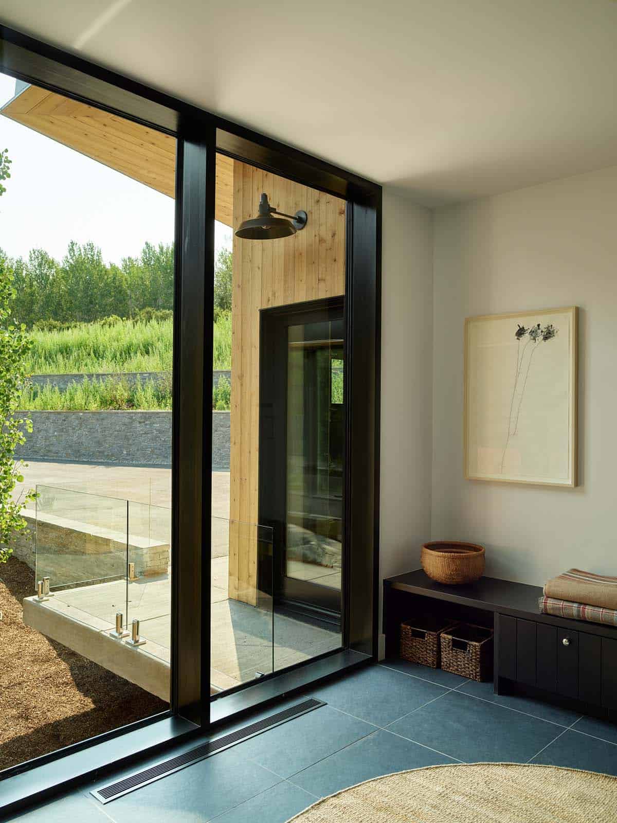 Entryway with black-framed glass door and built-in bench storage