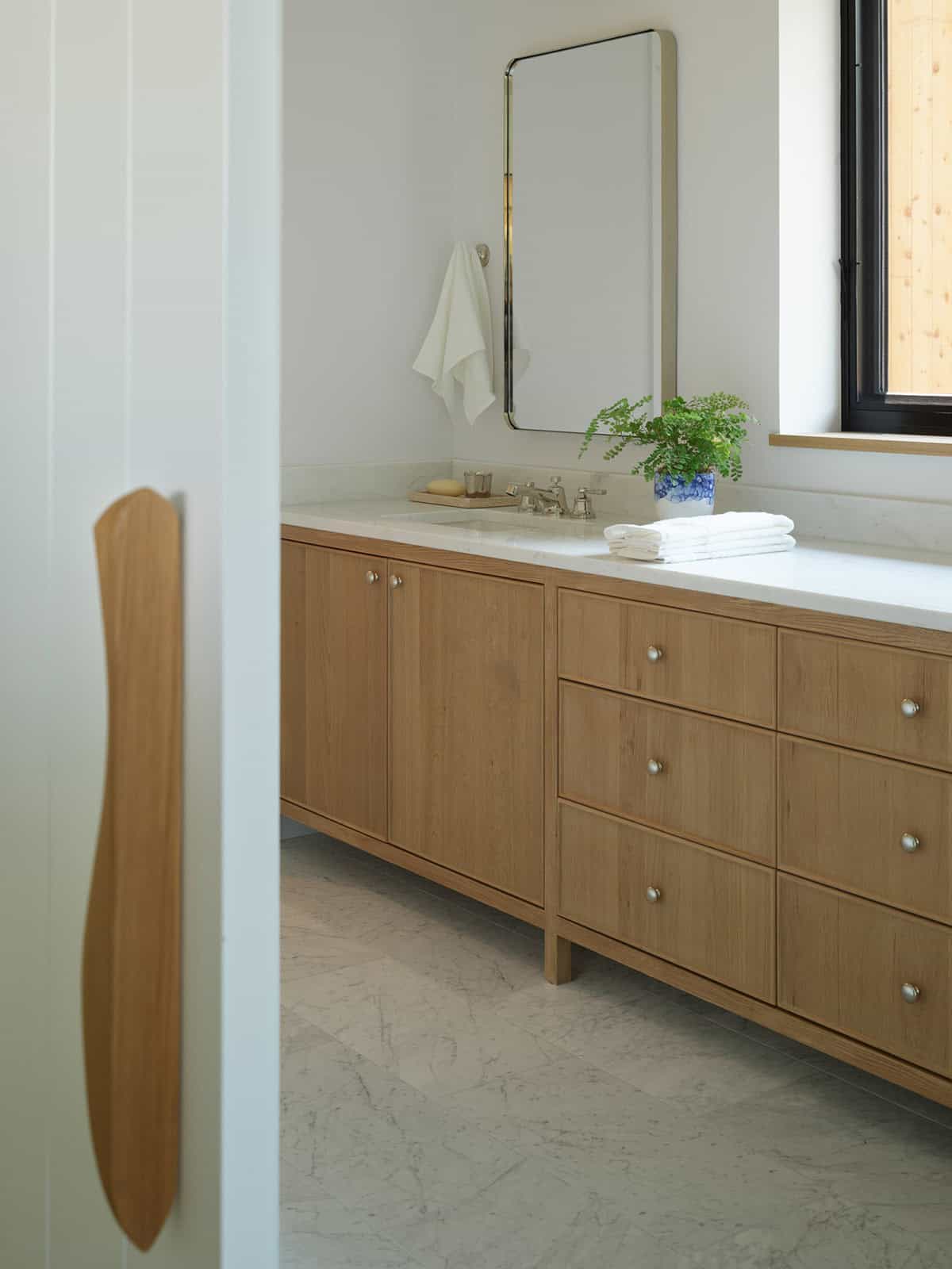 Bathroom vanity with wood cabinetry and marble countertop