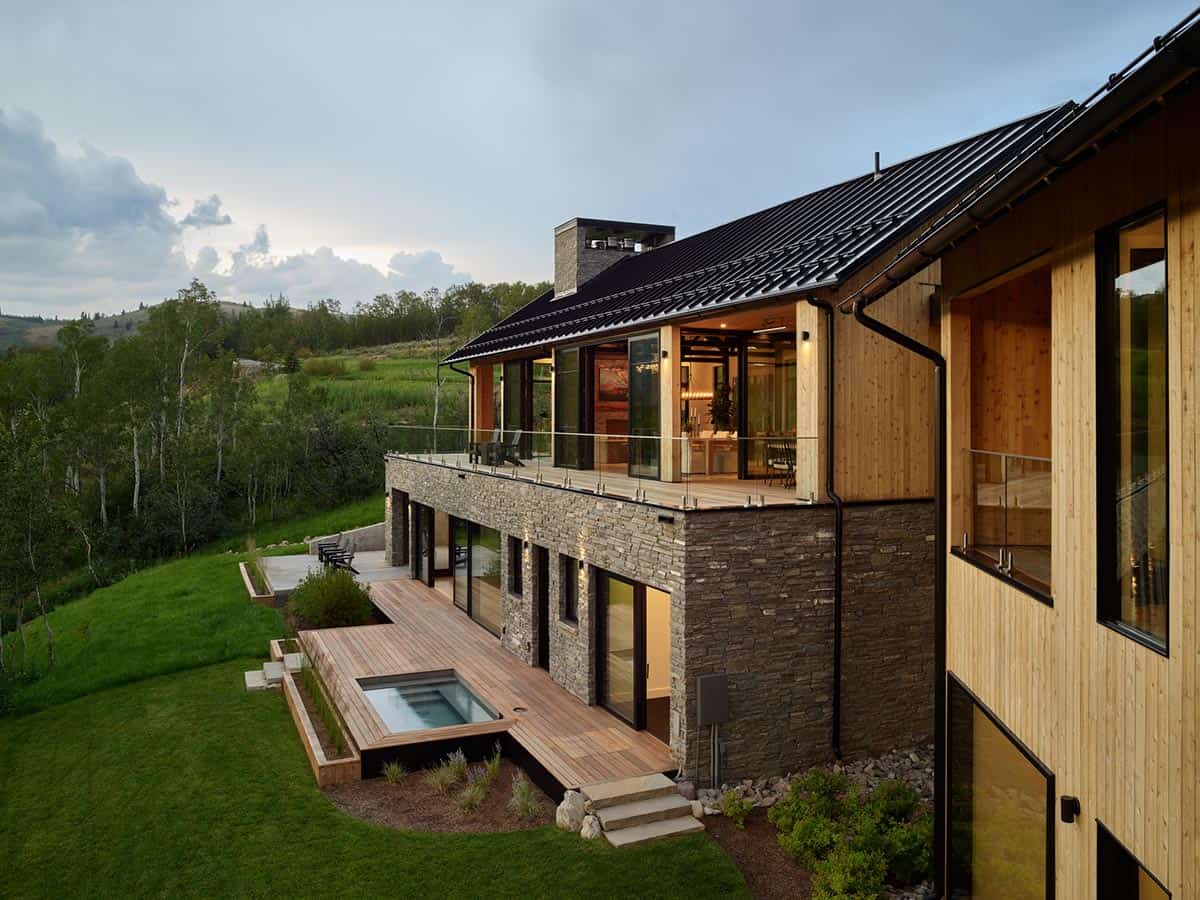 Aerial view of stone and wood home with rooftop deck and plunge pool