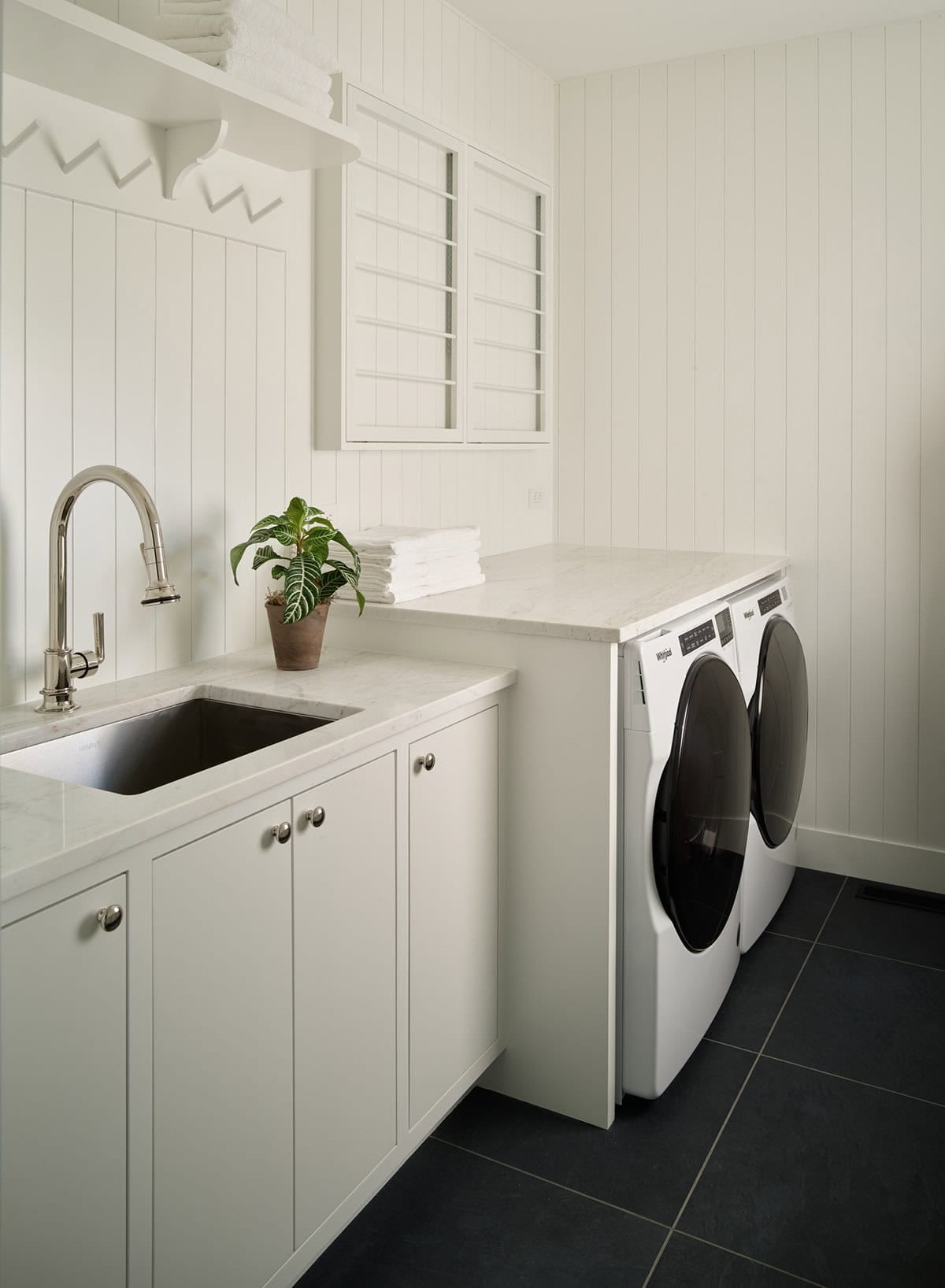 White laundry room with marble counter and washer dryer set