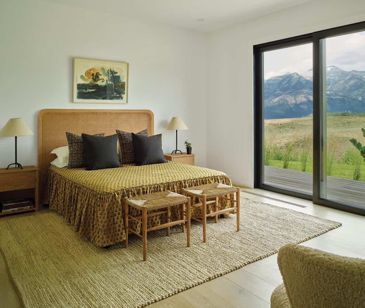 Bedroom with rattan headboard and sliding glass door overlooking mountains
