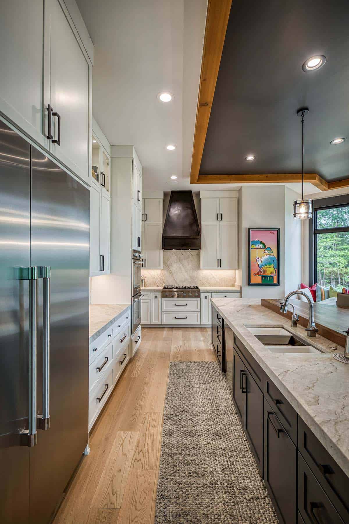 Galley kitchen view with stainless refrigerator, white cabinets, and stone backsplash