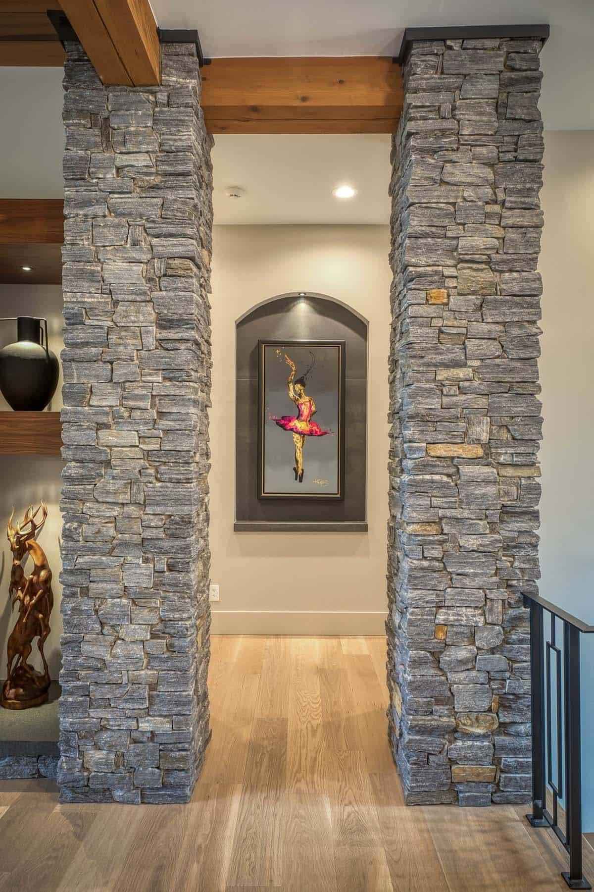 Stone-clad archway leading to illuminated art niche with ballerina painting