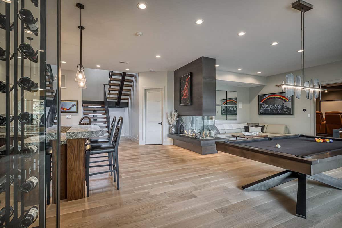 Basement game room with pool table, wine cellar, staircase, and sectional seating