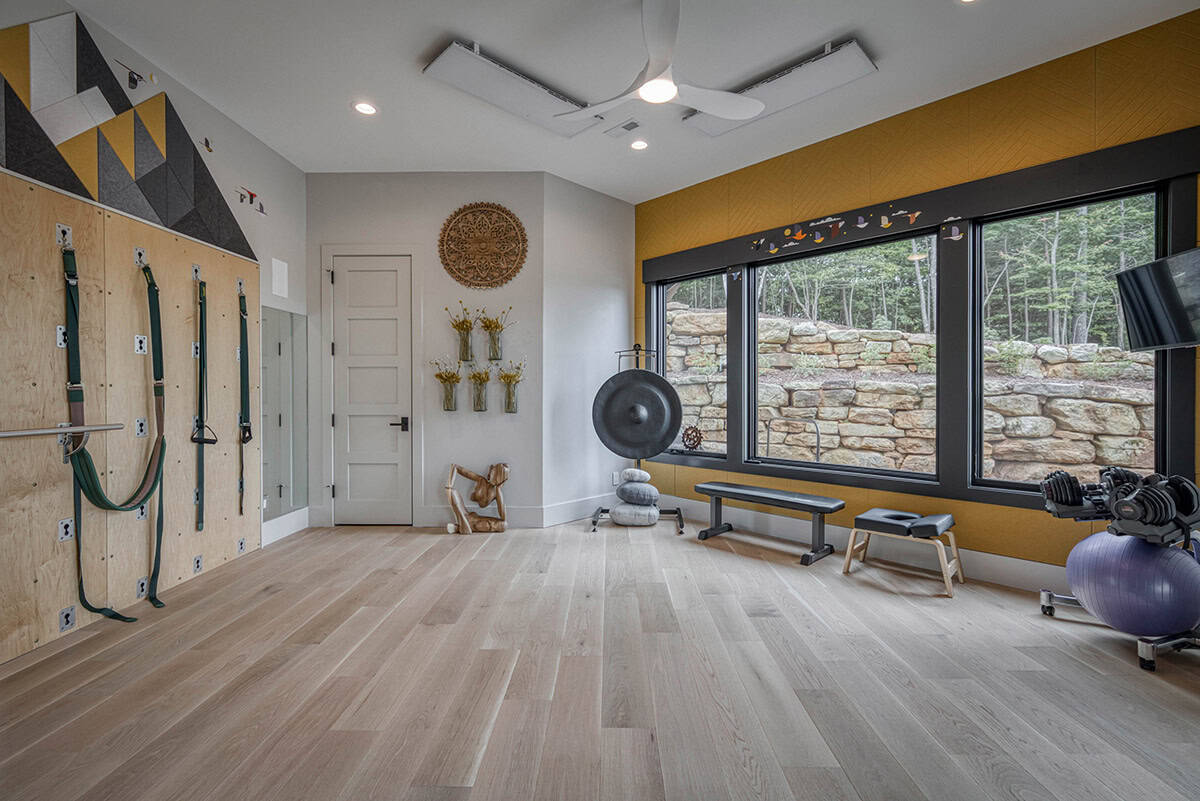 Home gym with resistance bands, exercise equipment, and large windows facing stone wall