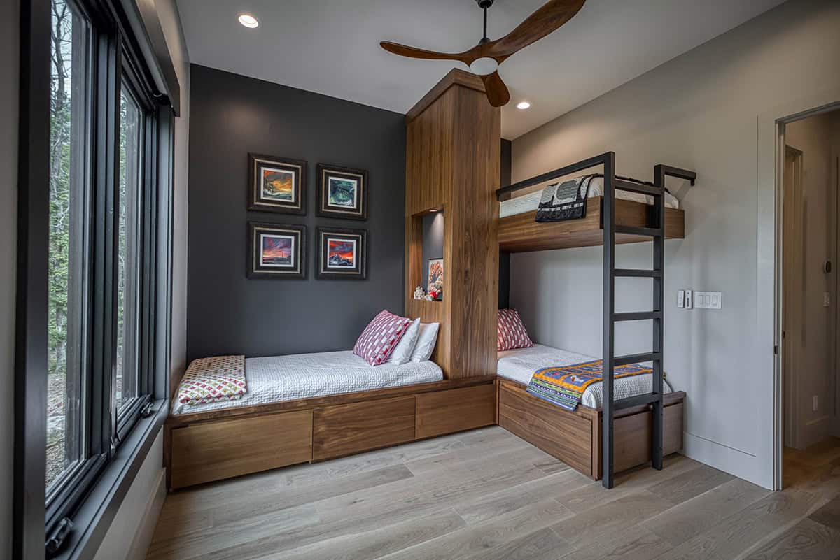 Kids' bedroom with twin bed, built-in bunk beds, and colorful artwork on dark accent wall