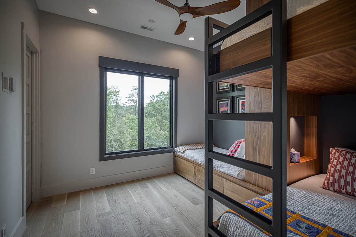Bunk room view showing window, twin bed, and ladder to upper bunk