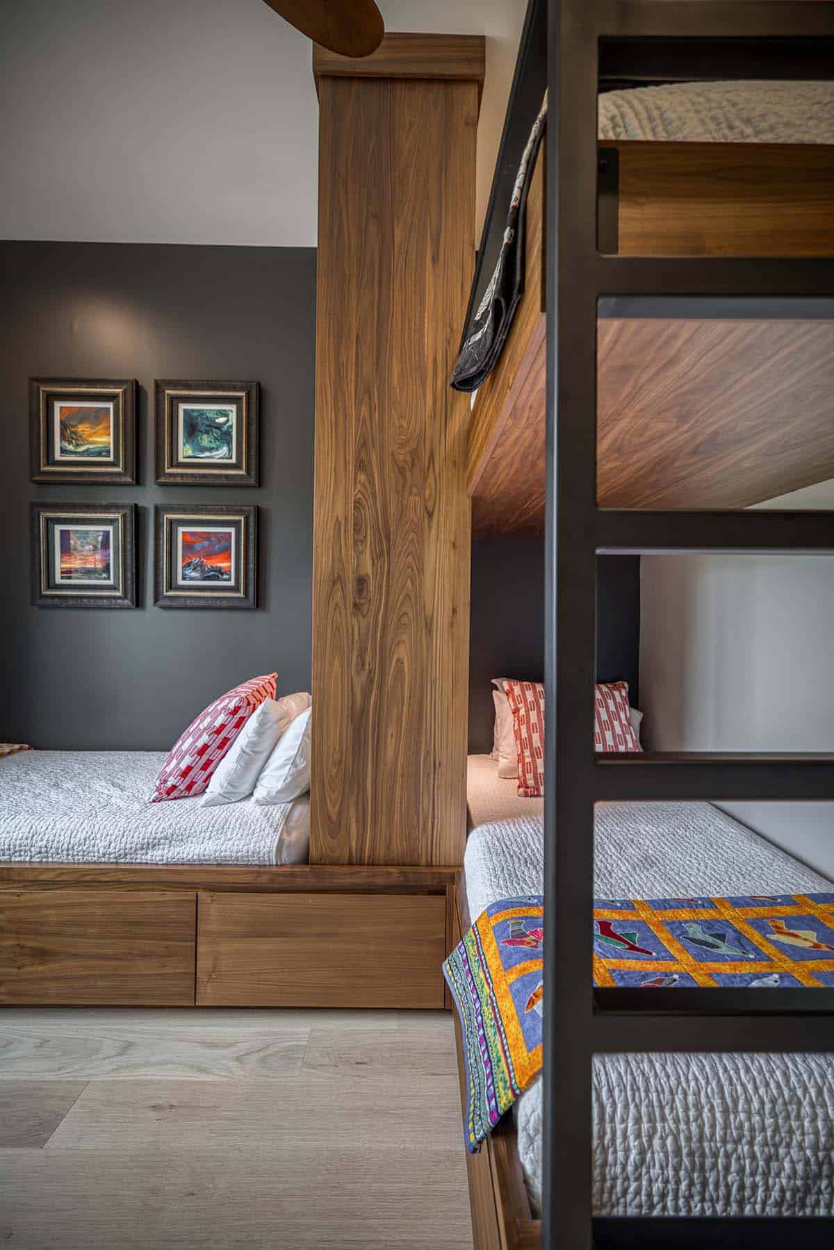 Close-up of bunk bed ladder and twin beds with quilted bedding and wood divider