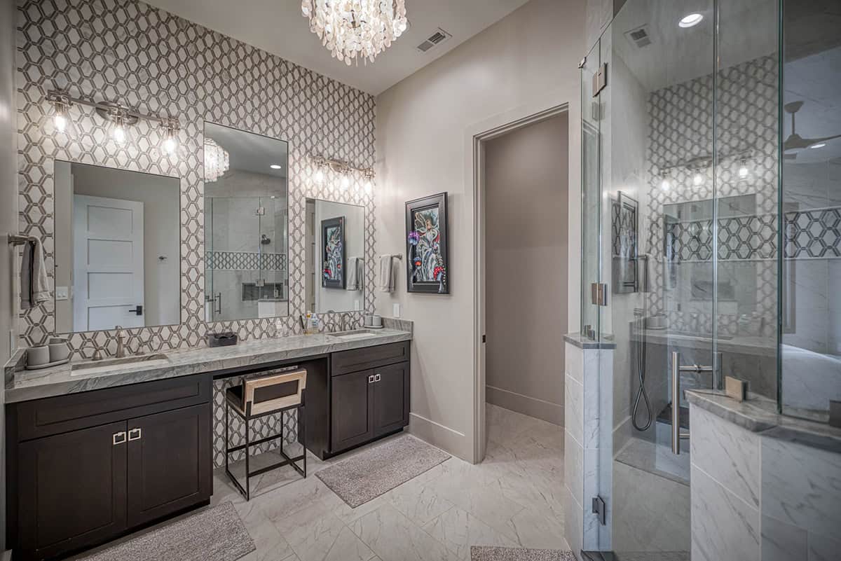 Bathroom with geometric tile backsplash wall, double vanity, and glass shower enclosure