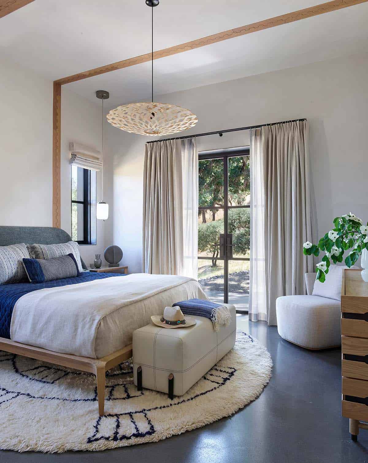 Primary bedroom with wood-trimmed ceiling, round shag rug, and French doors to the garden