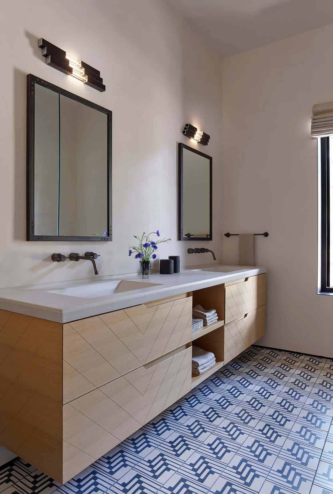 Double-sink bathroom vanity with chevron wood drawers and geometric blue floor tile