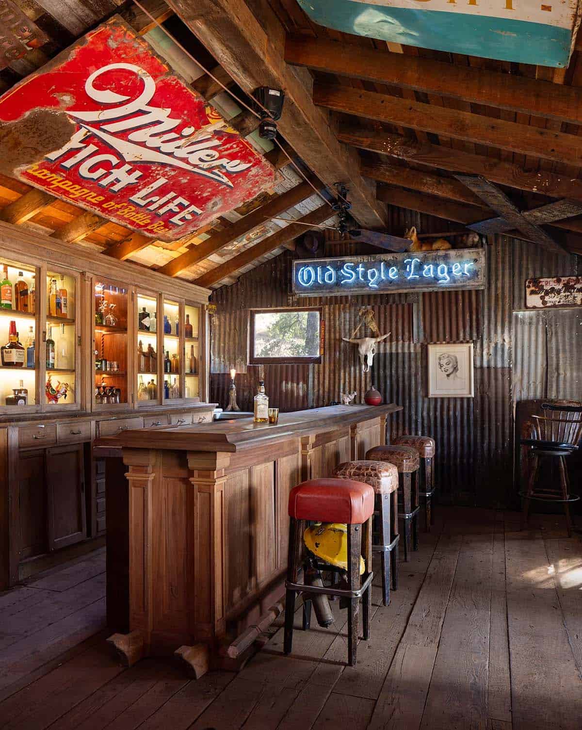 Vintage-style bar interior with backlit liquor cabinet and neon "Old Style Lager" sign