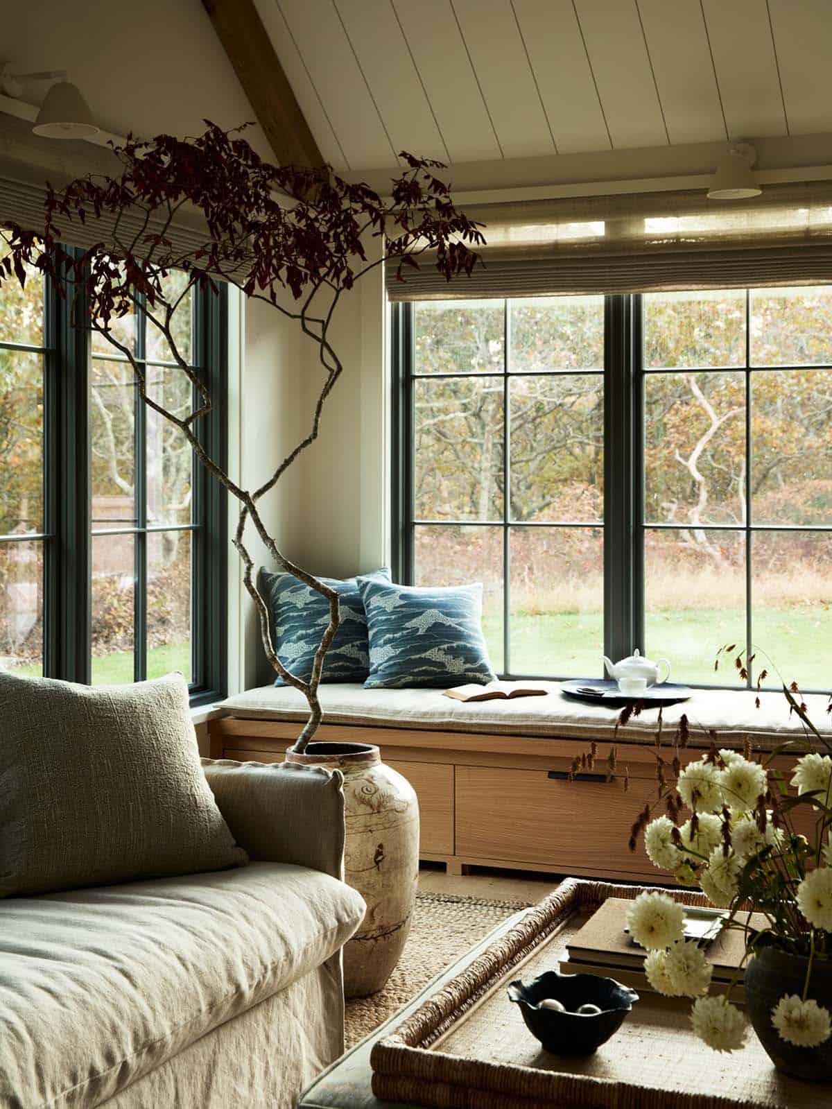 Window seat nook with blue printed pillows and faux branches