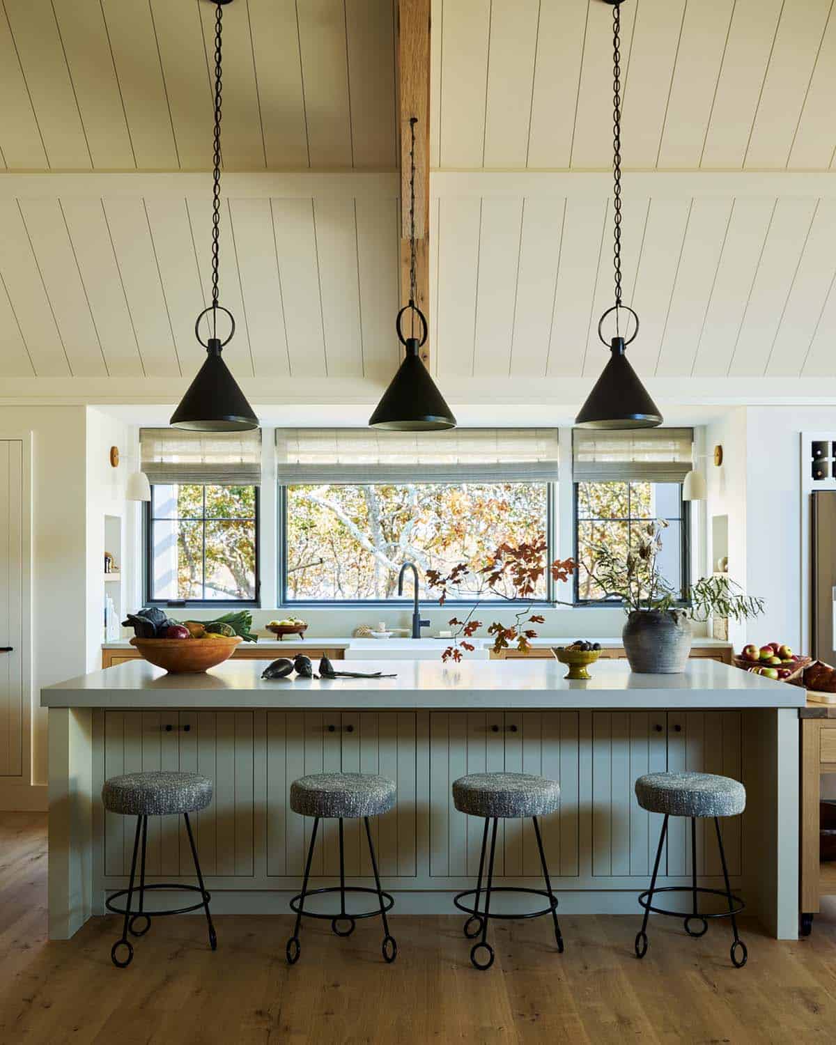 Kitchen island with black cone pendants and farmhouse sink view