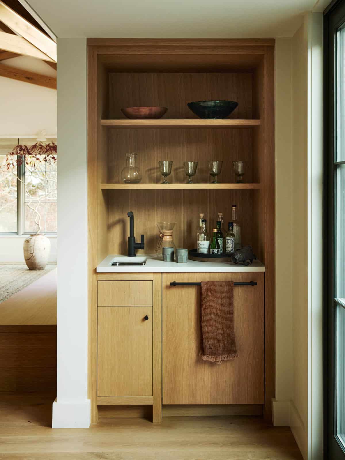 Built-in wet bar nook with open shelving and black fixtures