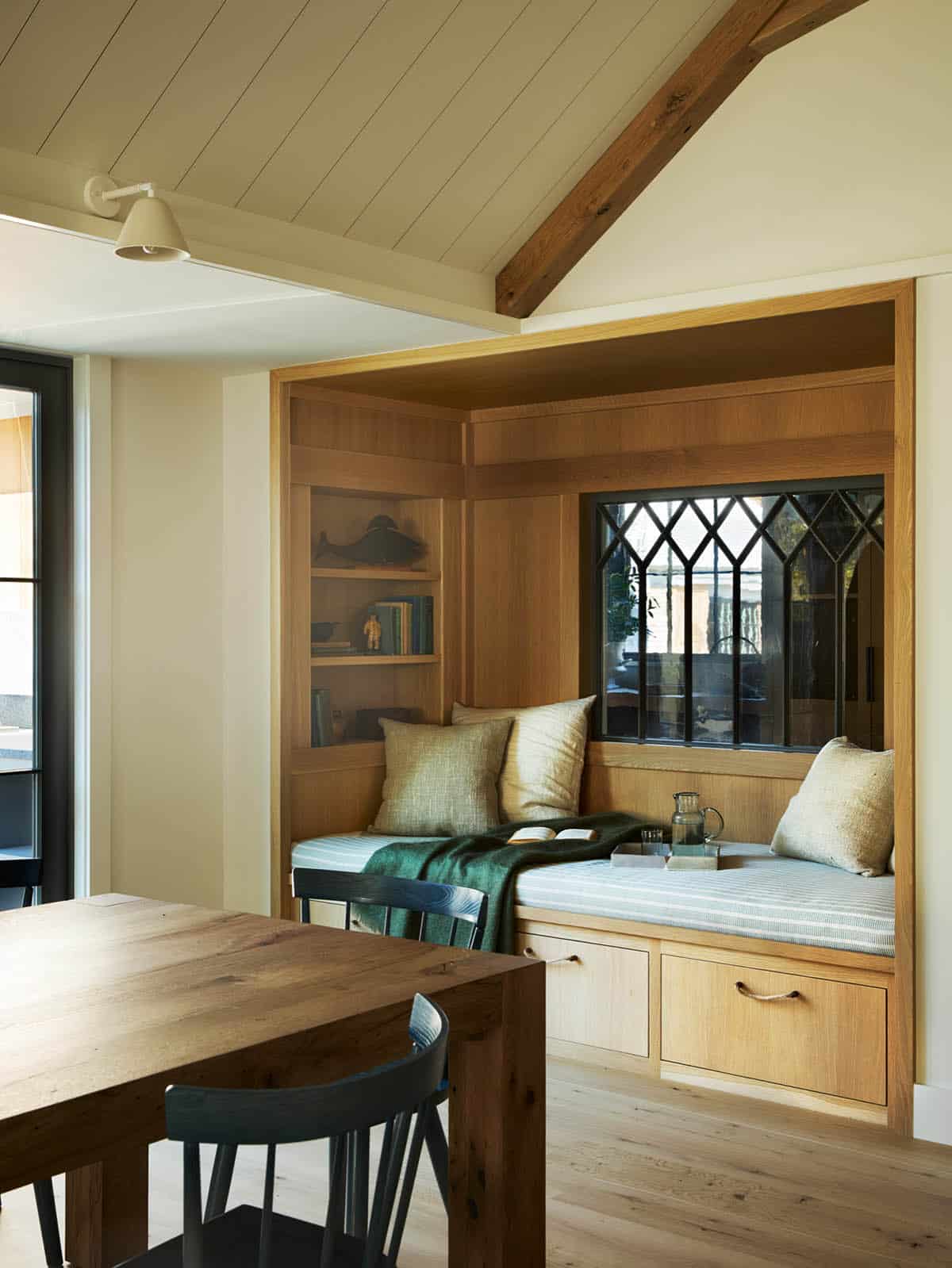 Built-in reading nook with striped cushion and leaded glass window