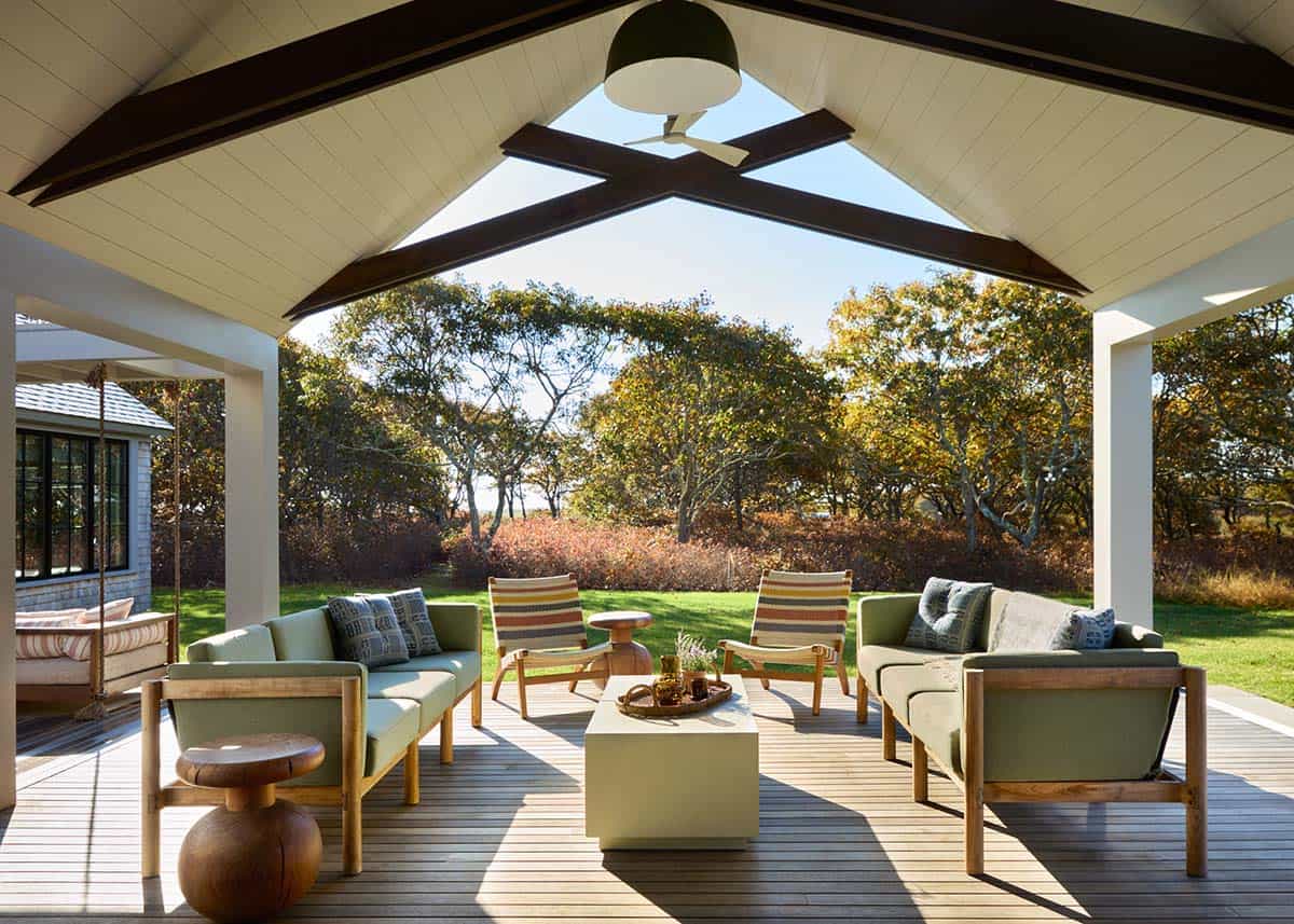 Covered porch with green upholstered seating and vaulted wood ceiling