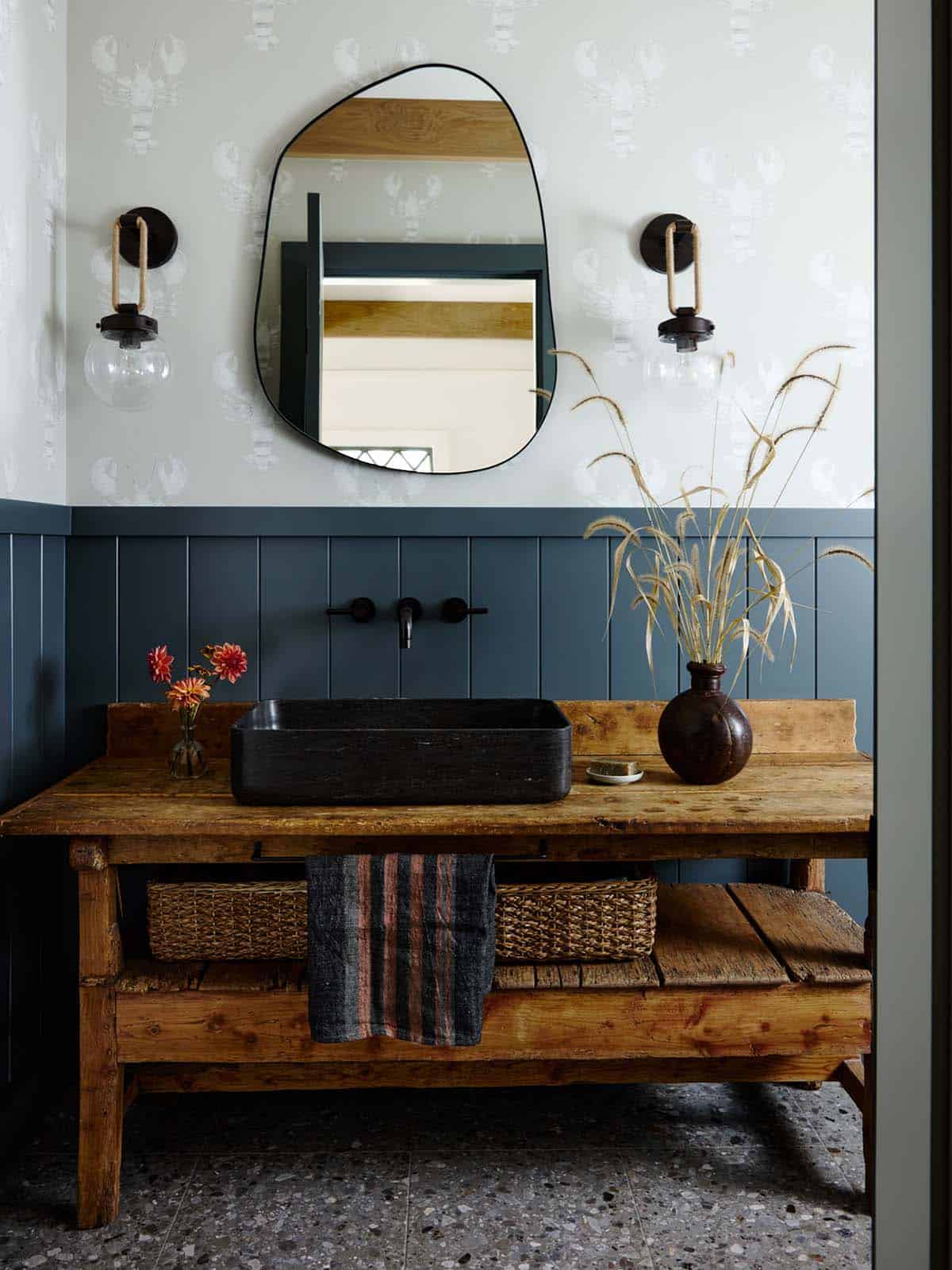 Powder room vanity with black stone sink and lobster print wallpaper