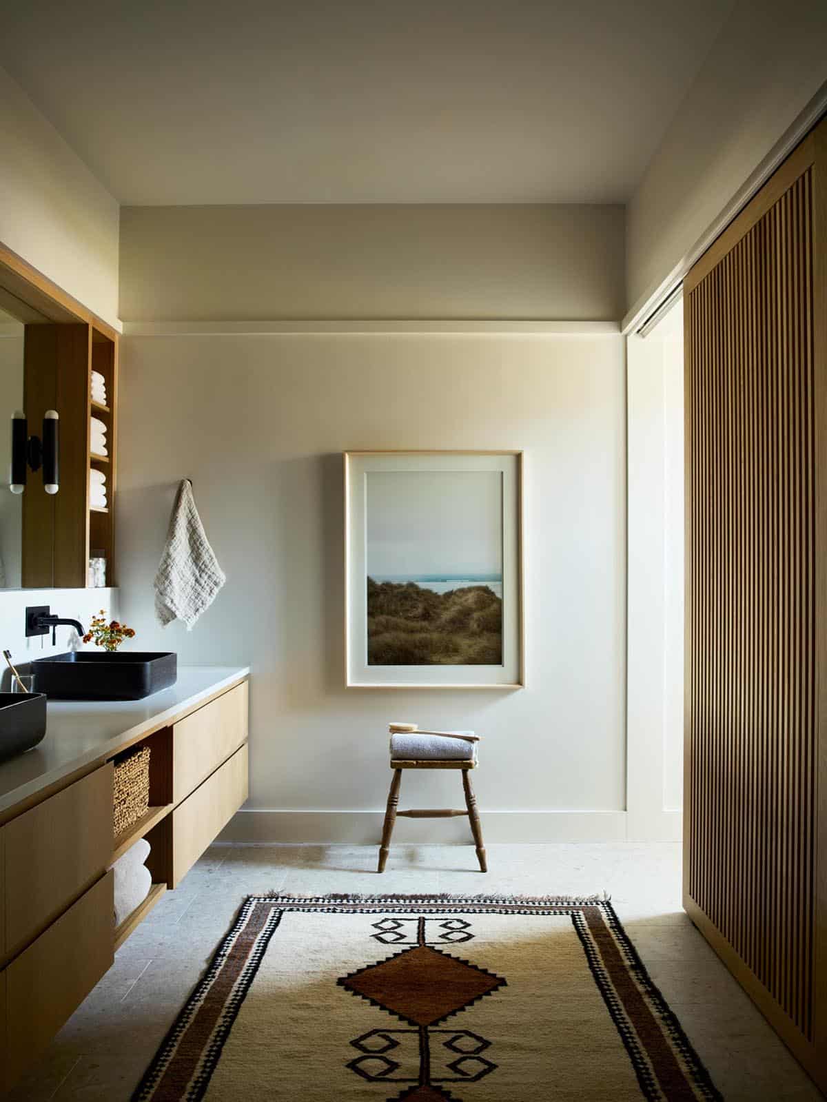 Bathroom with black stone sink and a patterned vintage runner rug
